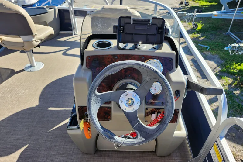 Slide: The Image of 2023 Sun Tracker Bass Buggy 18 DLX steering console with gauges and controls. - 20