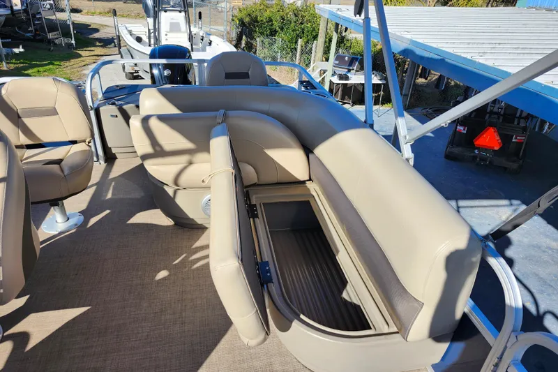 Slide: The Image of 2023 Sun Tracker Bass Buggy 18 DLX pontoon boat with beige seating and storage compartment. - 24