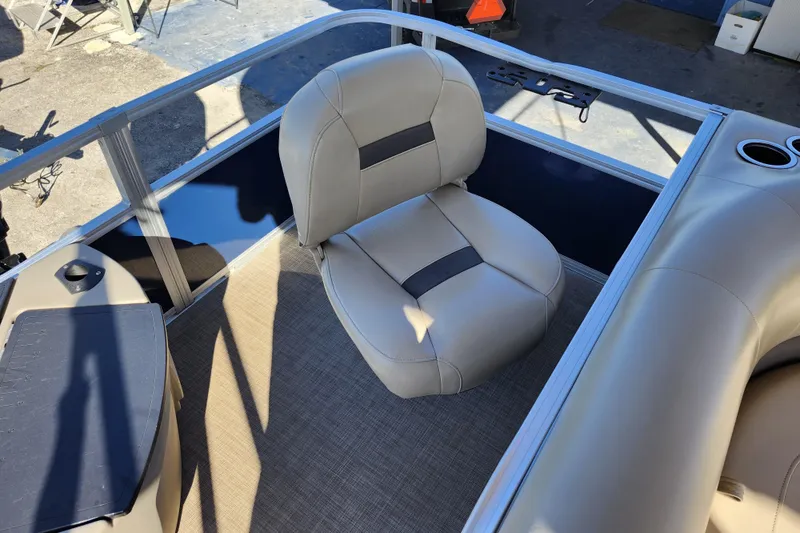 Slide: The Image of 2023 Sun Tracker Bass Buggy 18 DLX boat interior with beige seating and cup holders. - 33