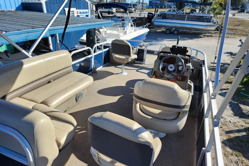 Slide: The Image of 2023 Sun Tracker Bass Buggy 18 DLX pontoon boat interior with beige seating and steering console. - 36