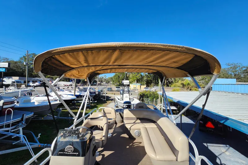 Slide: The Image of 2023 Sun Tracker Bass Buggy 18 DLX pontoon boat with canopy, parked outdoors. - 42