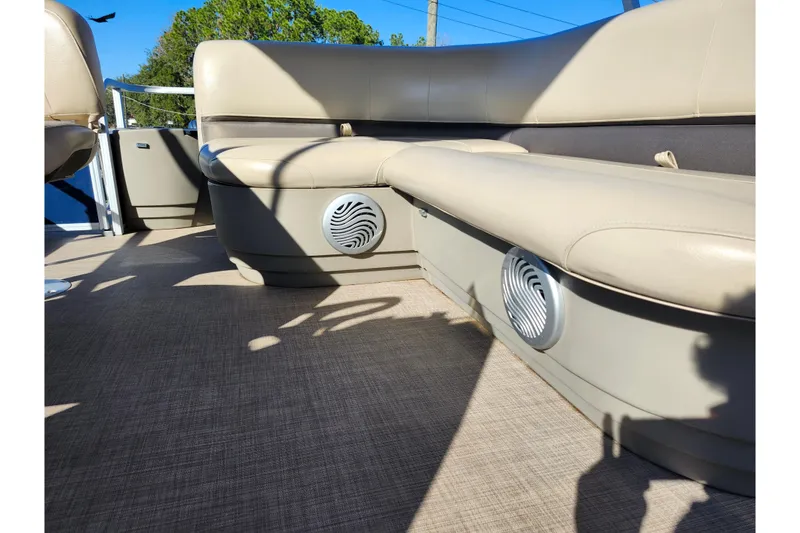 Slide: The Image of 2023 Sun Tracker Bass Buggy 18 DLX interior with beige seating and built-in speakers. - 45