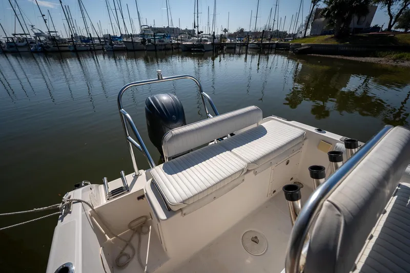 Slide: The Image of 2007 Century 2200 Center Console boat docked at marina, featuring seating and rod holders. - 14