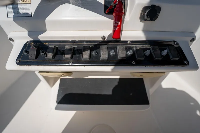 Slide: The Image of Control panel of a 2007 Century 2200 Center Console boat with switches and fire extinguisher. - 18
