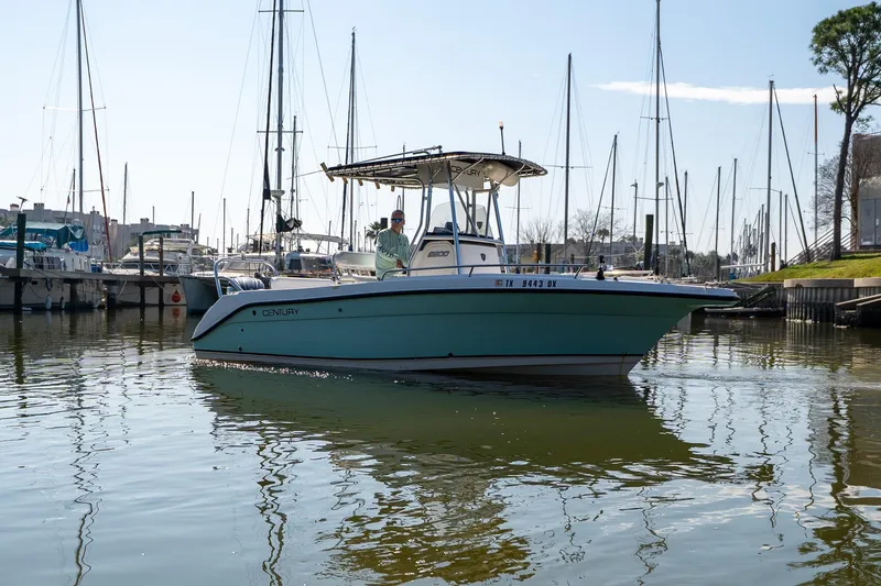 Slide: The Image of 2007 Century 2200 Center Console boat on calm marina waters with sailboats in background. - 2