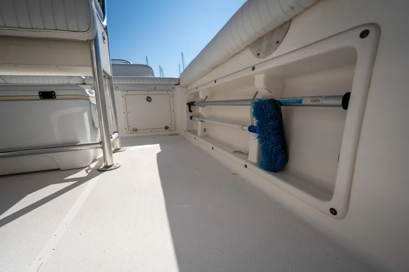 Slide: The Image of 2007 Century 2200 Center Console boat interior with storage compartment and cleaning brush. - 20