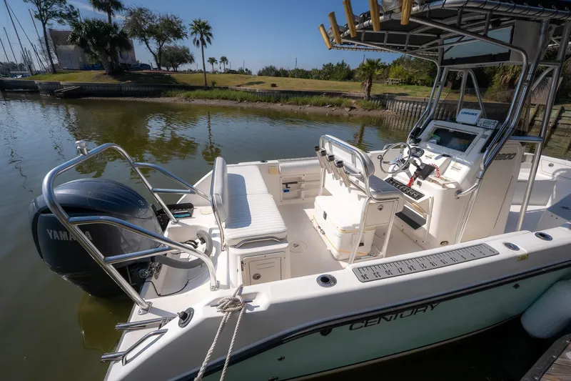 Slide: The Image of 2007 Century 2200 Center Console boat with Yamaha engine, docked by a scenic waterfront. - 27