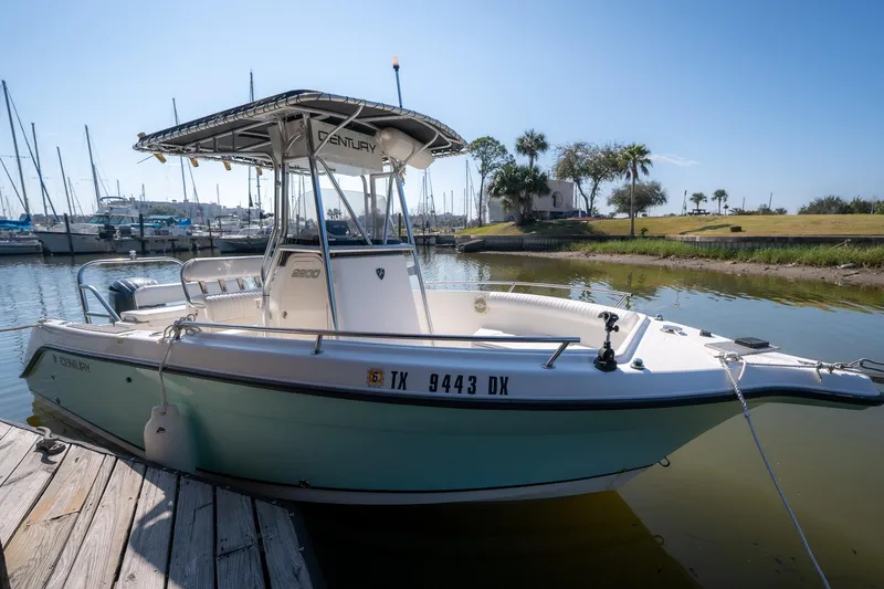 Slide: The Image of 2007 Century 2200 Center Console boat docked in a marina under clear blue skies. - 31