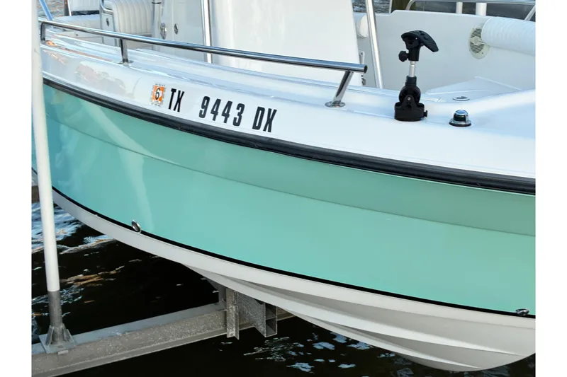 Slide: The Image of 2004 Century 2200 Center Console boat with mint green hull, docked on water. - 34