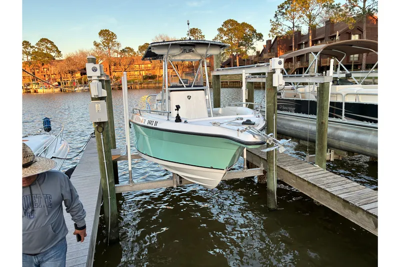 Slide: The Image of 2004 Century 2200 Center Console boat docked at a marina with scenic waterfront view. - 42
