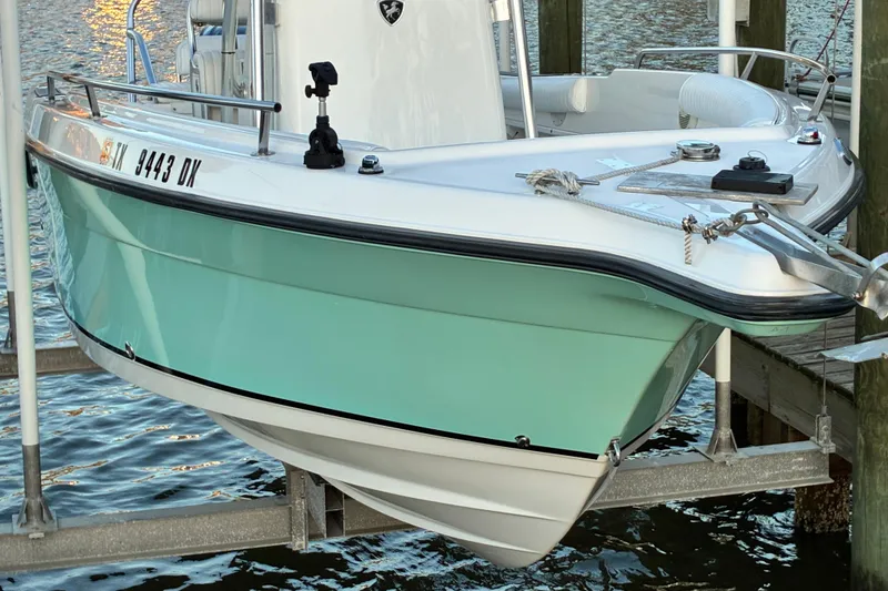 Slide: The Image of 2004 Century 2200 Center Console boat docked, featuring a sleek turquoise hull. - 43