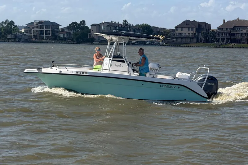 Slide: The Image of 2004 Century 2200 Center Console boat cruising on a lake with two passengers. - 44