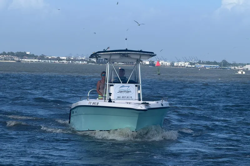 Slide: The Image of 2004 Century 2200 Center Console boat cruising on a sunny day with coastal backdrop. - 48