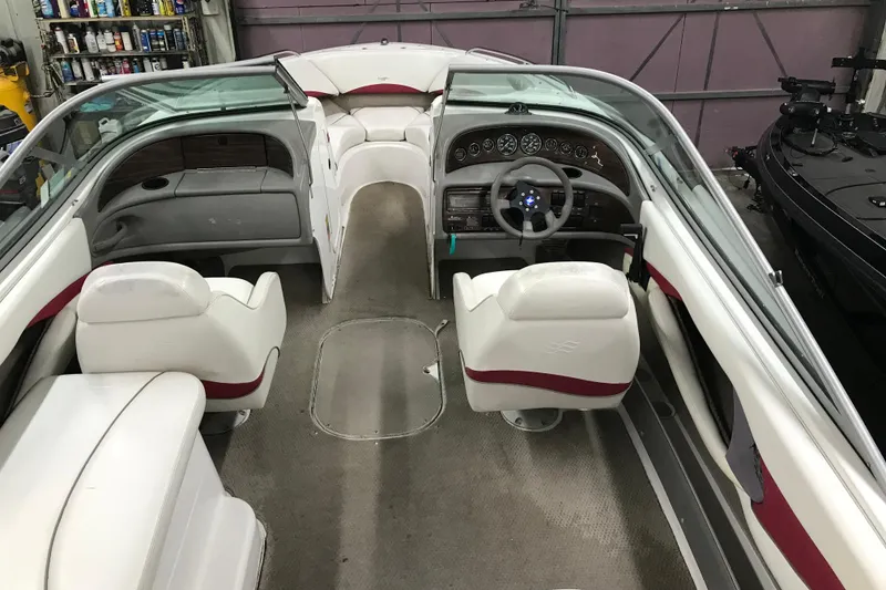 Slide: The Image of 2001 Four Winns 210 Horizon boat interior with white seating and dashboard in a garage. - 20