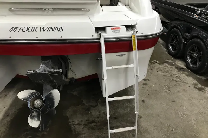 Slide: The Image of 2001 Four Winns 210 Horizon boat stern with ladder and propeller in garage. - 22