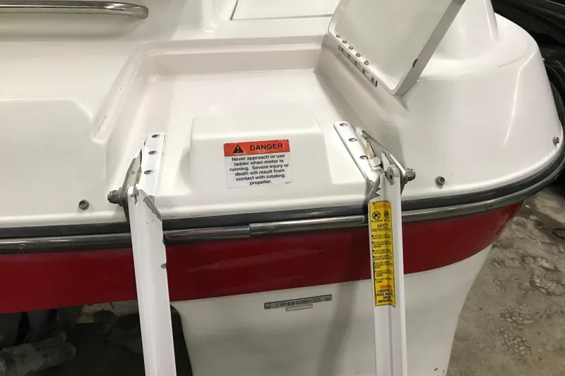 Slide: The Image of 2001 Four Winns 210 Horizon boat ladder with safety warning labels. - 25