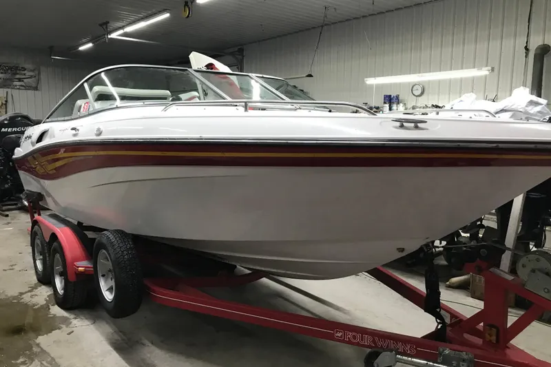 Slide: The Image of 2001 Four Winns 210 Horizon boat on trailer in indoor storage. - 6