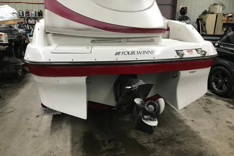 Slide: The Image of 2001 Four Winns 210 Horizon boat in a garage, rear view with visible propeller. - 7