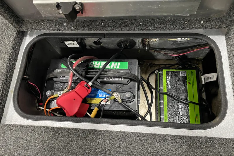 Slide: The Image of Battery compartment of a 2015 Triton 178 DV boat with wiring and charger. - 11