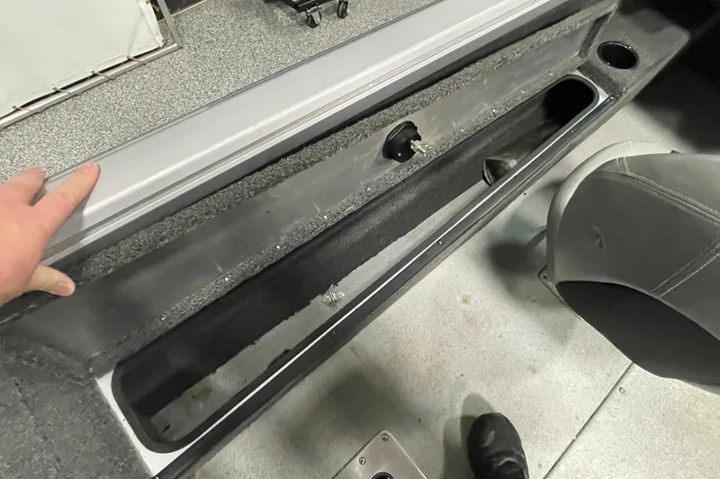 Slide: The Image of 2015 Triton 178 DV boat interior storage compartment with gray seating and flooring. - 14