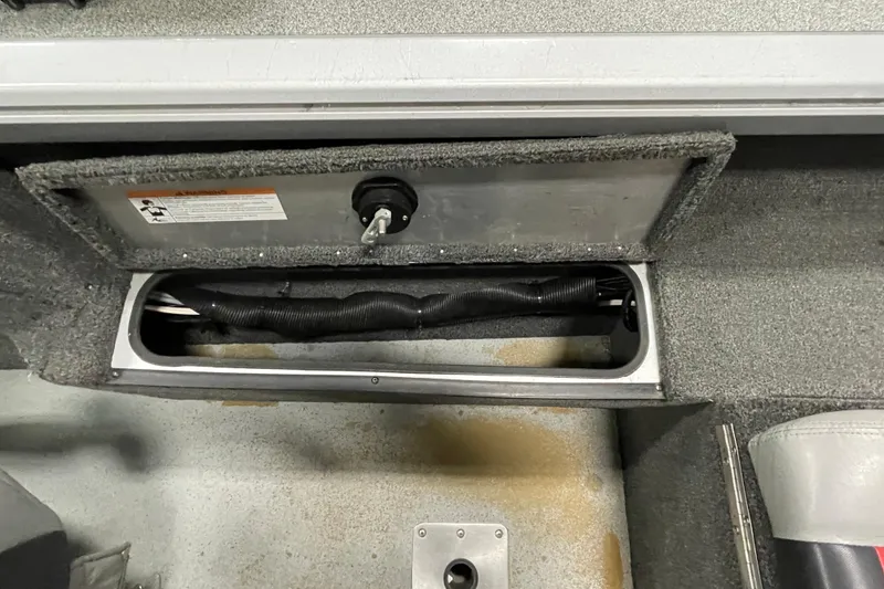 Slide: The Image of 2015 Triton 178 DV boat compartment with storage and wiring visible. - 15