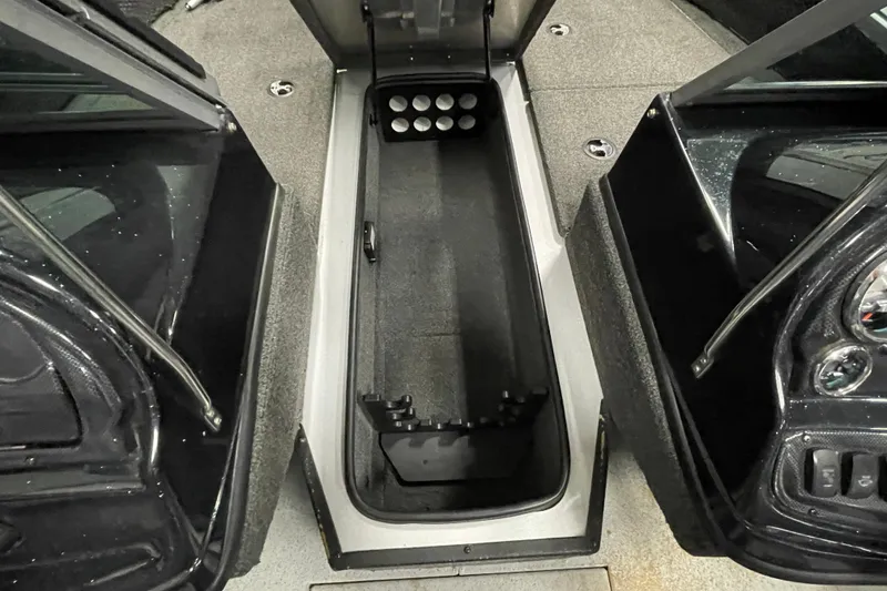 Slide: The Image of 2015 Triton 178 DV boat interior with storage compartment and carpeted flooring. - 16