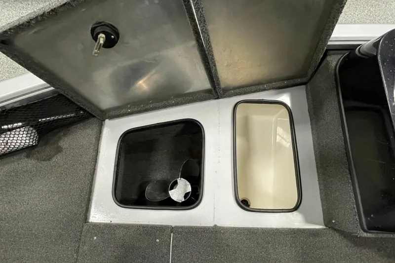 Slide: The Image of 2015 Triton 178 DV boat storage compartments with open lids and visible propeller. - 18