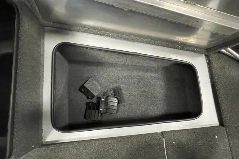 Slide: The Image of 2015 Triton 178 DV boat storage compartment with black brackets inside. - 19