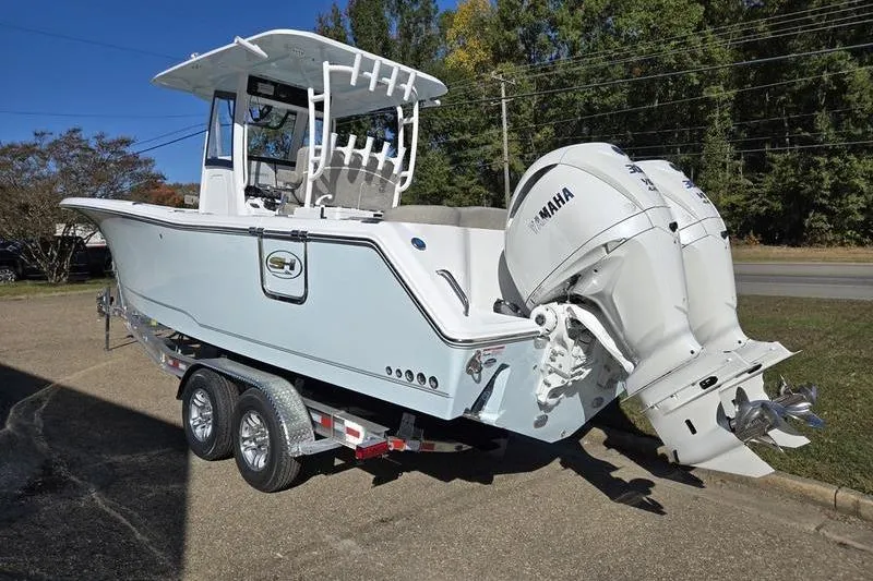 Slide: The Image of 2026 Sea Hunt Ultra 285 Coffin Box boat on trailer, featuring dual Yamaha engines. - 34