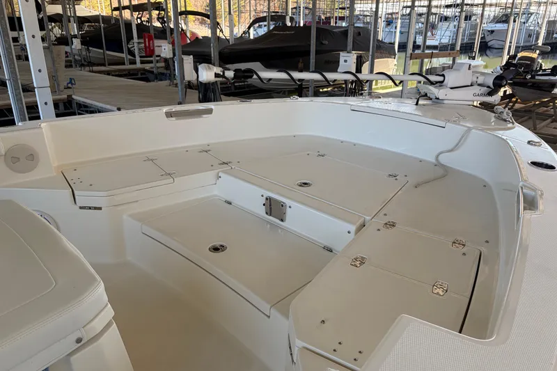 Slide: The Image of 2025 Pathfinder 2400 TRS boat interior with storage compartments and seating in a marina setting. - 6
