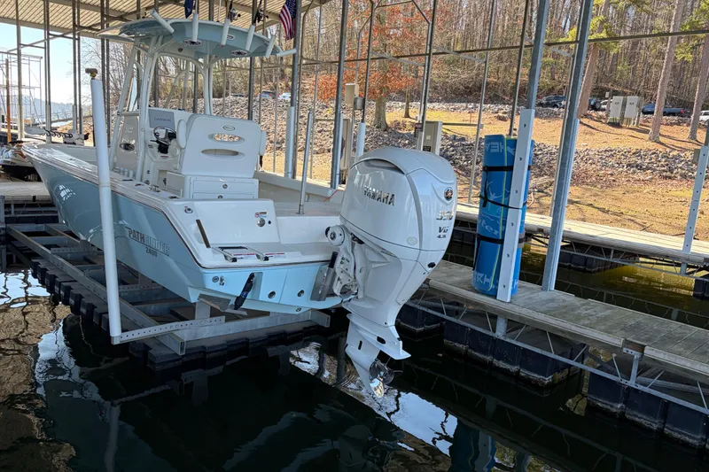 Slide: The Image of 2025 Pathfinder 2400 TRS boat docked with Yamaha outboard motor in a marina. - 7
