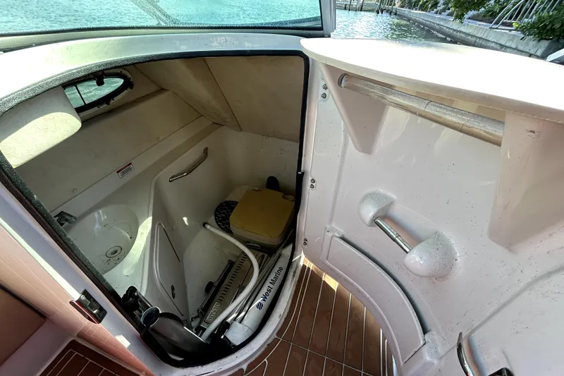 Slide: The Image of 2007 Sea Ray 260 Sundeck interior with compact bathroom and storage space. - 56