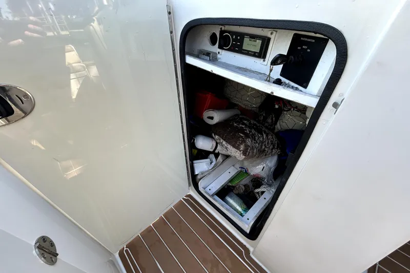 Slide: The Image of Storage compartment on a 2007 Sea Ray 260 Sundeck boat, showing various items inside. - 59