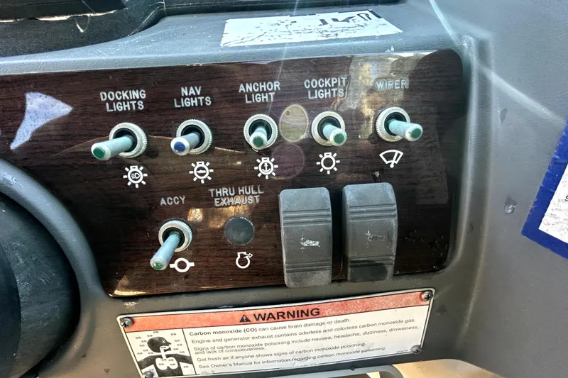 Slide: The Image of Control panel of a 2007 Sea Ray 260 Sundeck boat with various switches and warning label. - 67