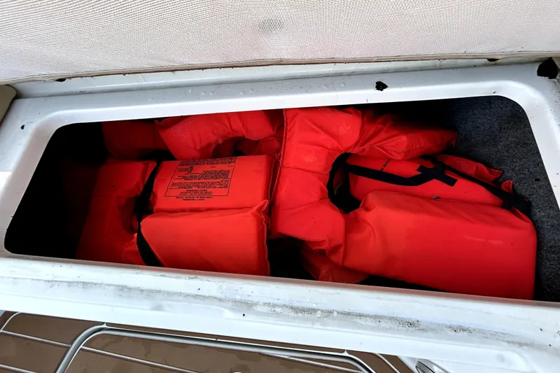 Slide: The Image of Storage compartment with orange life jackets on a 2007 Sea Ray 260 Sundeck boat. - 75