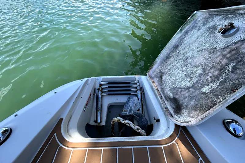 Slide: The Image of 2007 Sea Ray 260 Sundeck boat with open storage compartment near water. - 83