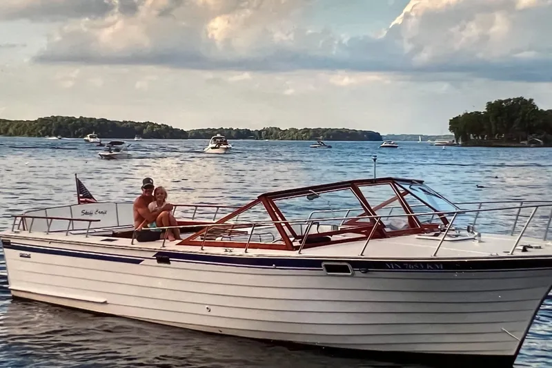 Slide: The Image of 1987 Skiff Craft 31' Runabout on a lake with people enjoying a sunny day. - 3