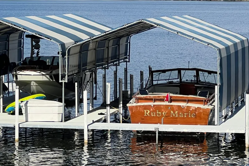 Slide: The Image of 1987 Skiff Craft 31' Runabout "Ruby Marie" docked under striped canopy. - 6