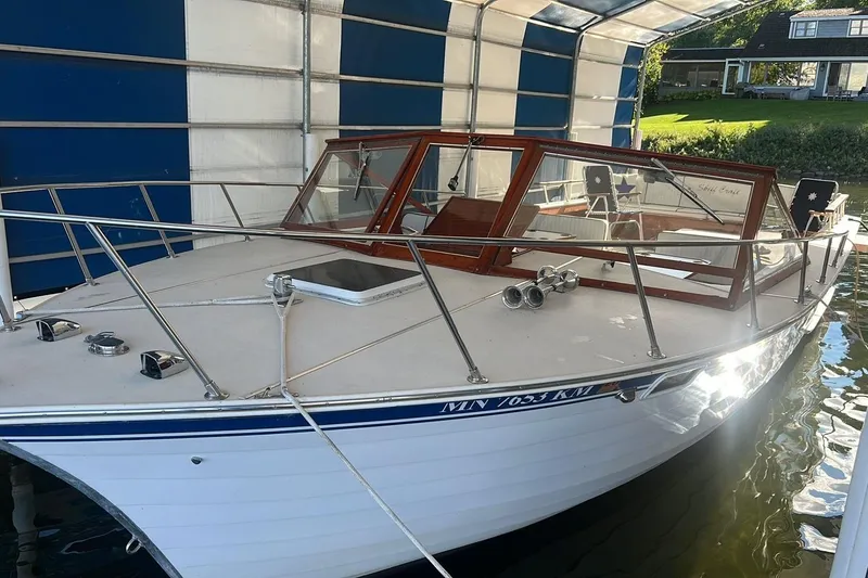 Slide: The Image of 1987 Skiff Craft 31' Runabout boat docked under a blue and white canopy. - 7