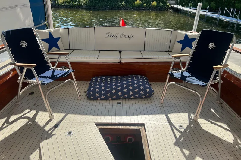 Slide: The Image of 1987 Skiff Craft 31' Runabout interior with nautical-themed seating and star-patterned cushions. - 8