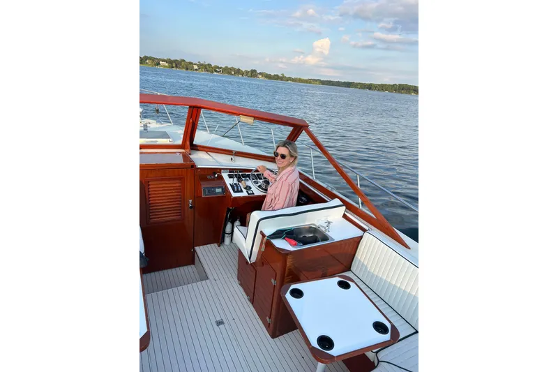 Slide: The Image of 1987 Skiff Craft 31' Runabout on a serene lake, featuring a person at the helm. - 9