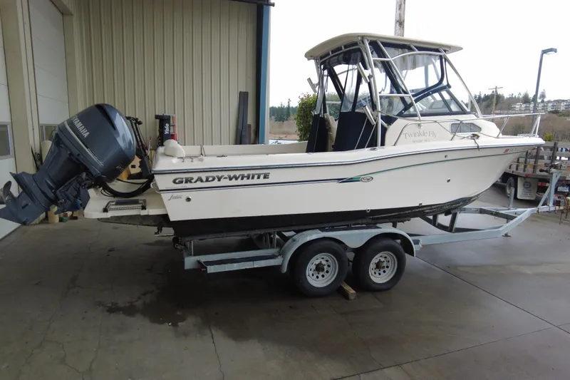 The Image of 2016 Grady-White Seafarer 228 boat on trailer, parked near a building. - 1