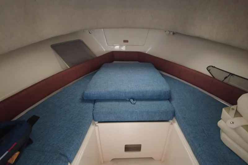 Slide: The Image of 2016 Grady-White Seafarer 228 cabin interior with blue cushions and storage space. - 7