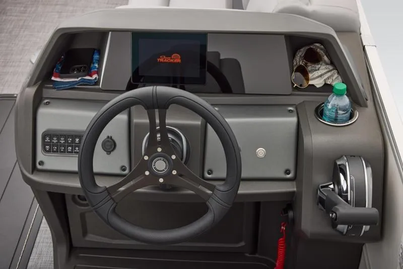 Slide: The Image of 2026 Sun Tracker Party Barge 22 DLX helm with steering wheel, controls, and storage compartments. - 42
