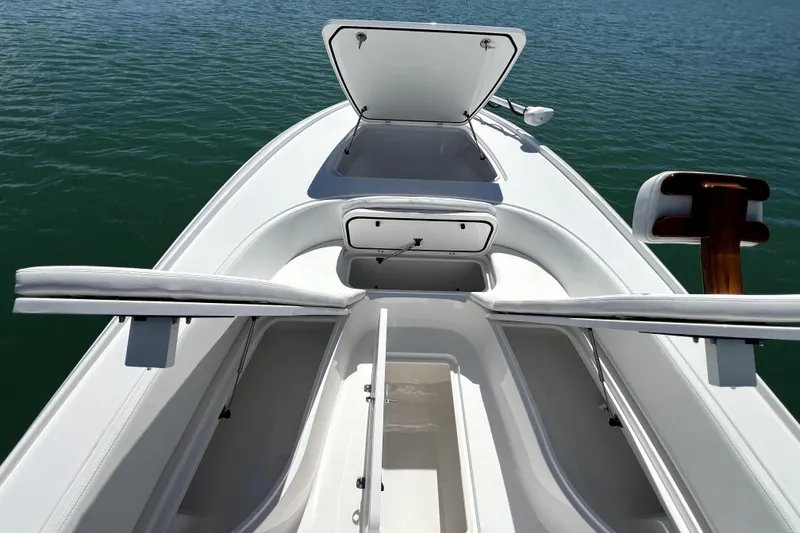 Slide: The Image of 2026 Contender 26 Bay boat interior with open storage compartments on calm water. - 13