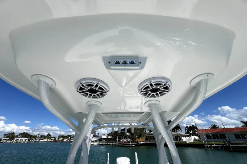 Slide: The Image of 2026 Contender 26 Bay boat T-top with speakers, overlooking a scenic waterfront. - 20