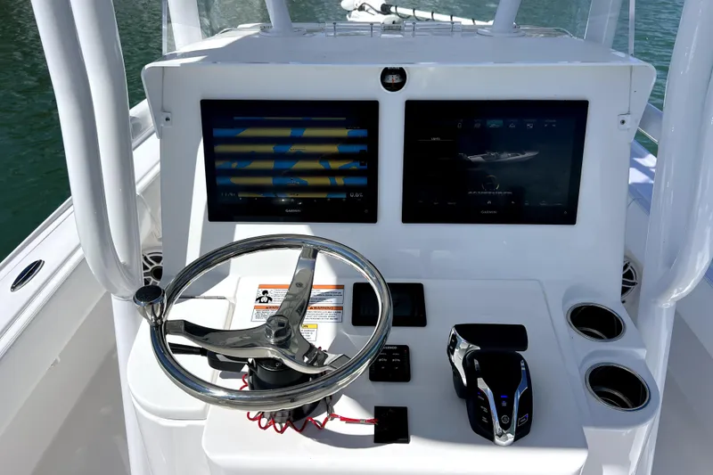 Slide: The Image of Helm of 2026 Contender 26 Bay boat with dual Garmin displays and steering wheel. - 22