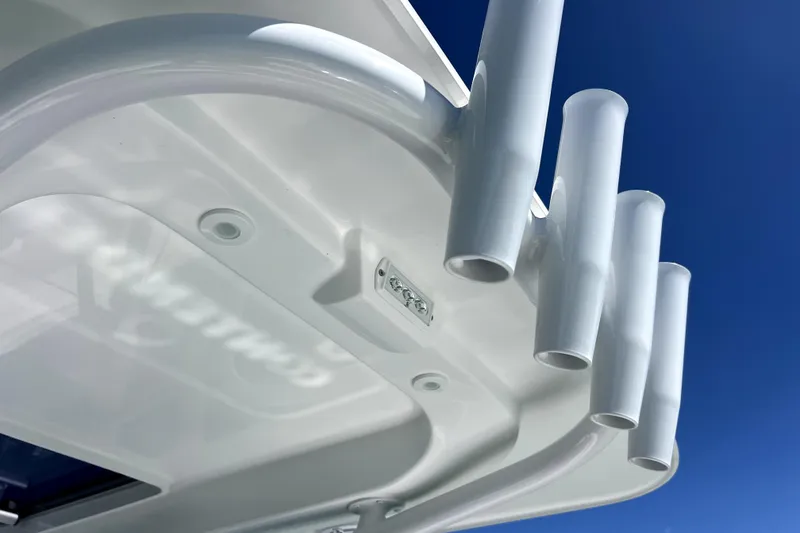 Slide: The Image of 2026 Contender 26 Bay boat detail with rod holders against clear blue sky. - 25