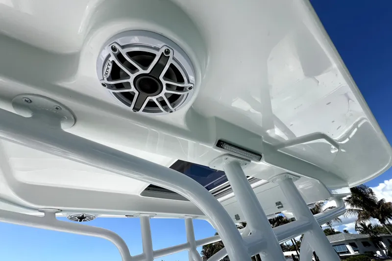 Slide: The Image of 2026 Contender 26 Bay boat with speaker and T-top against blue sky. - 26