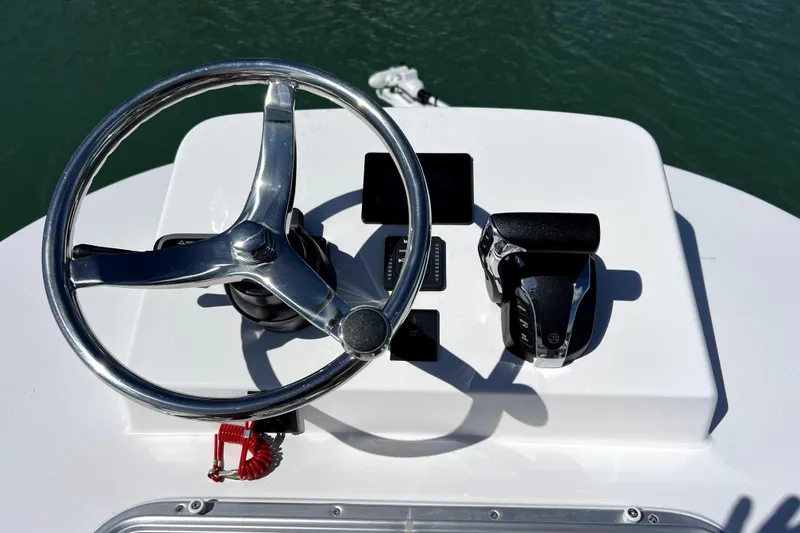 Slide: The Image of Steering wheel and controls of 2026 Contender 26 Bay boat on water. - 29